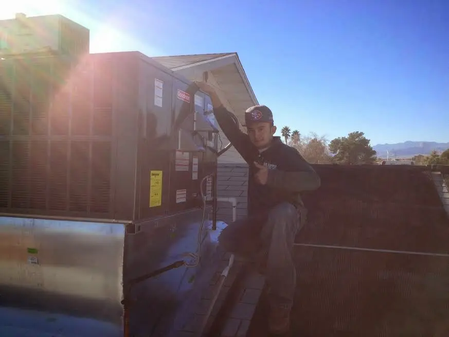 HVAC technician performing AC Tune-Up on a rooftop unit in Mantua